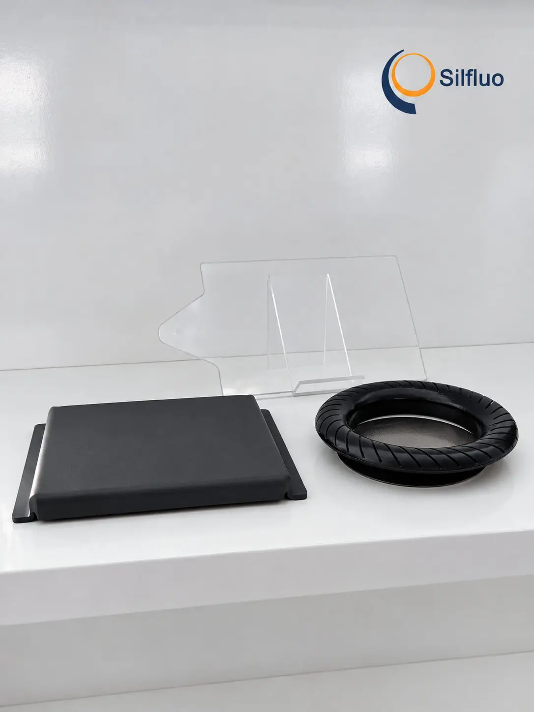 Matte black polysilazane ceramic coating on a flat steel sample panel and on a slotted brake-disc ring, shown on a white bench